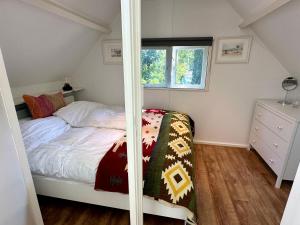 a small bedroom with a bed and a window at Vakantiehuis Flori in Bergen