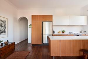 a kitchen with wooden cabinets and a stainless steel refrigerator at Coogee Treetops in Sydney