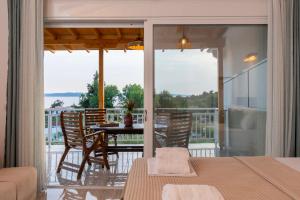 a room with a balcony with a table and chairs at Giota in Neos Marmaras