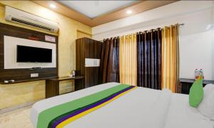 a bedroom with a bed and a flat screen tv at Mangal Residency in Bedla