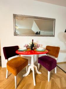 a dining room table with two chairs and a mirror at Hamilton Apartment in Craiova