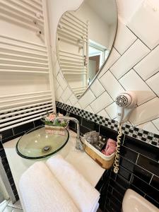 a bathroom with a sink and a mirror at Hamilton Apartment in Craiova