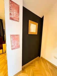 a room with a black accent wall and a mirror at Hamilton Apartment in Craiova