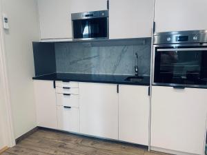 a kitchen with white cabinets and a microwave at Explore Stockholm Old Town in Stockholm