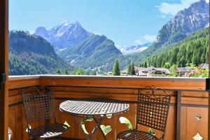 a table and chairs on a balcony with mountains at Albergo Majorka in Canazei