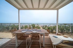 a dining table and chairs on a patio with a view at Villaggio San Francesco in Duna Verde
