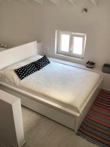 a bedroom with a large bed with a window at Bright and airy Village Studio Maisonette in Mytilinioí