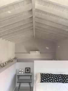 a white room with a bed and a table at Bright and airy Village Studio Maisonette in Mytilinioí