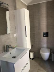 a bathroom with a white sink and a toilet at Bright and airy Village Studio Maisonette in Mytilinioí