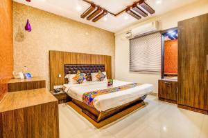 a bedroom with a large bed and a sink at FabExpress Mayuri Residency in Bangalore