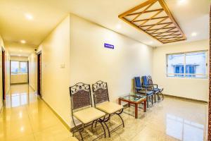 a waiting room with chairs and a table at FabExpress Mayuri Residency in Bangalore
