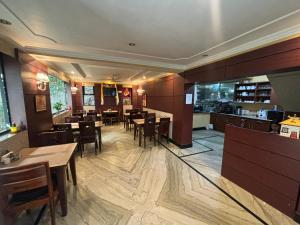 达兰萨拉New Serkong House的餐厅里有桌椅的餐厅