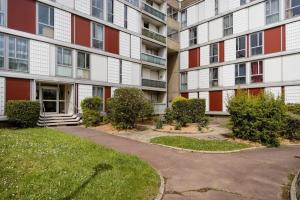 an apartment building with a pathway in front of it at Chambre d'hôte chez Marie-Jeanne in Pierrefitte-sur-Seine