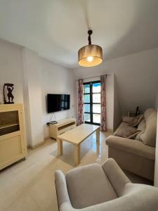 una sala de estar con un sofá y una mesa en Nuevo y exclusivo ático de playa, en Fuengirola