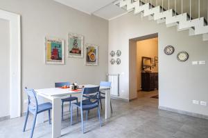 a dining room with a white table and blue chairs at Appartamento Ferdinando - Relax & Style in Caserta