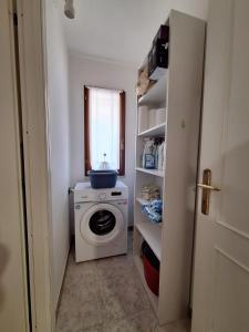 a laundry room with a washing machine and a window at Apposentu Sant'Antioco in SantʼAntìoco