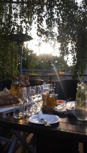 a table with glasses and plates of food on it at Rooftop terrace Green Sky in Vilnius