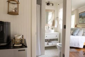 a bathroom with a sink and a toilet and a bed at Historic Coastal Suite Steps to the Water - Suite One in Fairhope