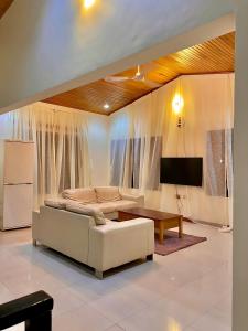 a living room with a white couch and a tv at Ghouse room A Ideal For Friends family And Corporate in Lateman