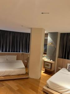 a hotel room with two beds and a desk at Kyoto Boutique Hotel in Johor Bahru