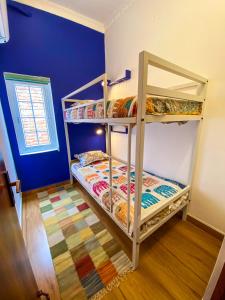 two bunk beds in a room with a blue wall at Comfort & Cozy, Villa in Orchha