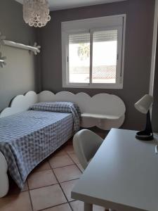 Un dormitorio con una cama y una mesa y una ventana. en La casa familiar, en Puerto Real 5 fotos más