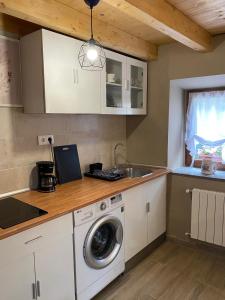 a kitchen with a washing machine and a sink at Vivienda Vacacional La Quesería in Oceño +4 photos