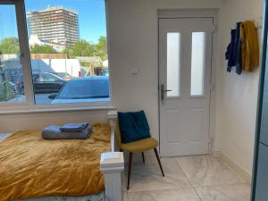 a bedroom with a bed and a chair and a window at Sunny Studio with Parking and Private Entrance in Bristol