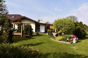 a woman sitting in the yard of a house at Wczasy u Gospodarza na Kaszubach in Kistowko