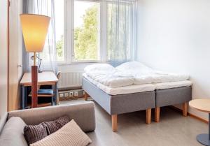 una camera da letto con un letto, un divano e una finestra di CityLoginn a Närpiö Altre 12 foto