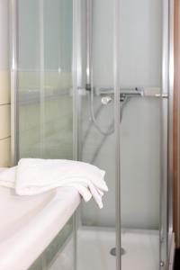 bagno con doccia e asciugamano bianco di CityLoginn a Närpiö