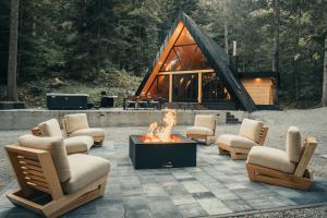 a fire pit in front of a log cabin at The Cozy Chalet in Bosanski Petrovac
