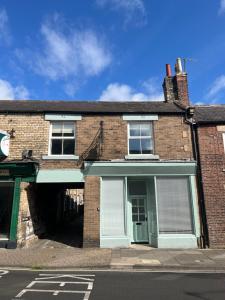 un vecchio edificio in mattoni con garage di Old Toy Shop - Cosy Flat in Central Hexham a Hexham