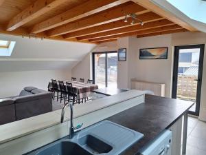 a kitchen and living room with a sink and a table at Le Logement de Vers les Champs in Lornay