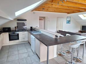 a kitchen with a large island in a room at Le Logement de Vers les Champs in Lornay +4 photos