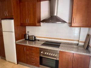 a kitchen with wooden cabinets and a stove top oven at GINVA - Dúplex en Plaza de España in El Puerto de Santa María +15 photos