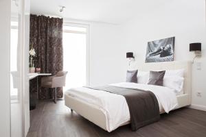 een witte slaapkamer met een bed en een bureau bij Konventchen in Aschaffenburg