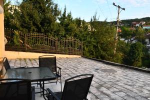 un patio avec une table et des chaises et une clôture dans l'établissement Apartment Germia, à Pristina