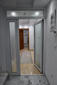 un couloir avec des portes en verre dans un bâtiment dans l'établissement Apartment Germia, à Pristina