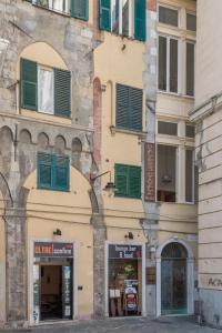 a building with green shuttered windows on it at Palazzo Cicala in Genova