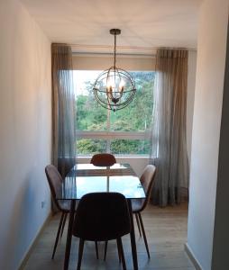 a dining room table with chairs and a window at HERMOSO y CÓMODO APARTAESTUDIO SABANETA in Sabaneta