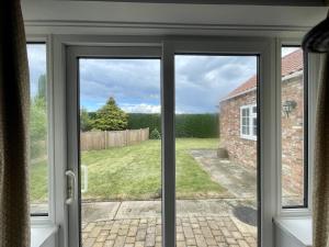 a sliding glass door with a view of a yard at Rodgers Land (The Bungalow) in Boston