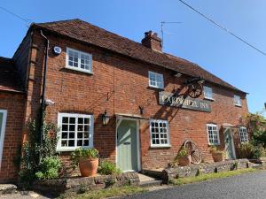 a red brick building with a sign on it at the Cartwheel Inn in Whitsbury