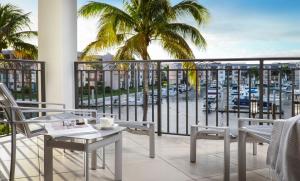 a balcony with tables and chairs and a view of a harbor at Naples Bay Resort and Marina in Naples