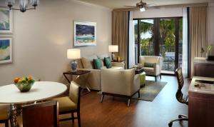 a living room with a table and chairs and a couch at Naples Bay Resort and Marina in Naples