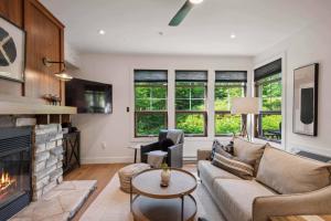 un salon avec un canapé et une cheminée dans l'établissement Tremblant Prestige - Les Eaux 223-4, à Mont-Tremblant
