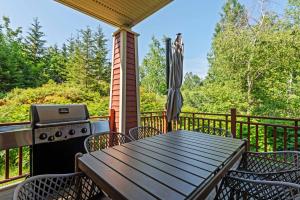 a table and chairs on a deck with a grill at Tremblant Prestige - Les Eaux 223-4 in Mont-Tremblant