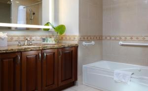 a bathroom with a tub and a sink and a toilet at Naples Bay Resort and Marina in Naples