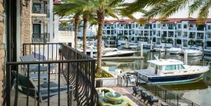 a balcony with palm trees and a boat in a marina at Naples Bay Resort and Marina in Naples