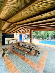 a pavilion with a picnic table and benches on a patio at Paraiso del Cauca in Jericó